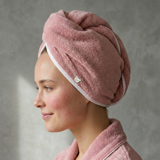 Woman wearing the PureRain pink microfibre hair towel wrap for anti-frizz quick-drying